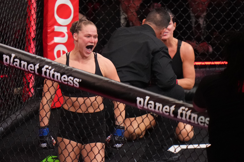 Ronda Rousey, of the United States, left, celebrates after defeating Gina Carano, of the United States, right, in their featherweight mixed martial arts fight Saturday, May 16, 2026, in Inglewood, Calif. (AP Photo/Jae C. Hong )
