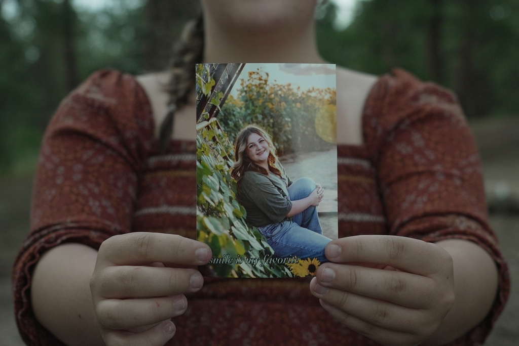Charlotte Touzalin holds a photo of herself, provided by Bre Blake Photography, showing her before participating in a PMOS study, in Elizabeth, Colo., on Friday, July 10, 2026. (AP Photo/Brittany Peterson, Bre Blake Photography)