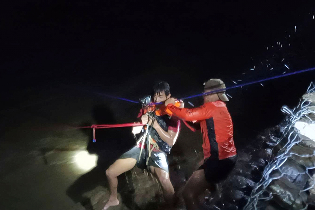 In this photo provided by the Philippine Coast Guard, a man is rescued from a swollen river as Super Typhoon Ragasa affects Salcedo, Ilocos Sur province, northern Philippines, Monday, Sept. 22, 2025. (Philippine Coast Guard via AP)