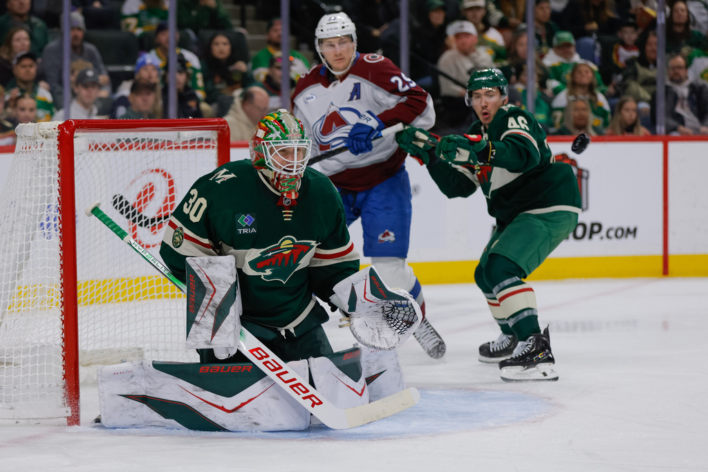 Minnesota Wild goaltender Jesper Wallstedt (30) watches the puck while defenseman Jared Spurgeon (46) defends against Colorado Avalanche center Nathan MacKinnon (29) during the second period of an NHL hockey game Friday, Nov. 28, 2025, in St. Paul, Minn. (AP Photo/Bailey Hillesheim)