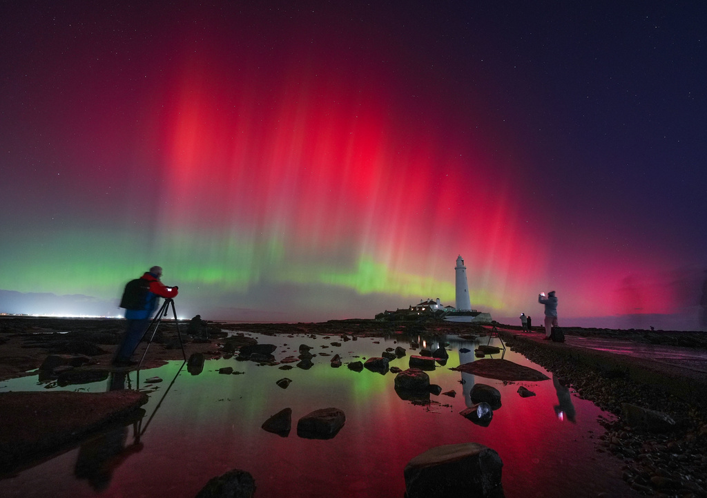 The aurora borealis, also known as the northern lights, glow in the sky over St Mary's Lighthouse in Whitley Bay on the North East coast, England, Wednesday Nov. 12, 2025. (Owen Humphreys/PA via AP)