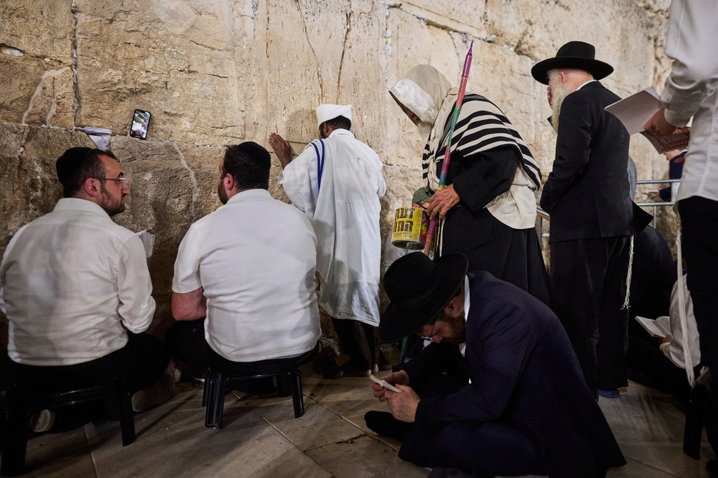 Ultra-orthodox Jewish men pray during the mourning ritual of Tisha B'Av at the Western Wall, Judaism's holiest site, in Jerusalem's Old City, Wednesday, July 22, 2026. (AP Photo/Ohad Zwigenberg)