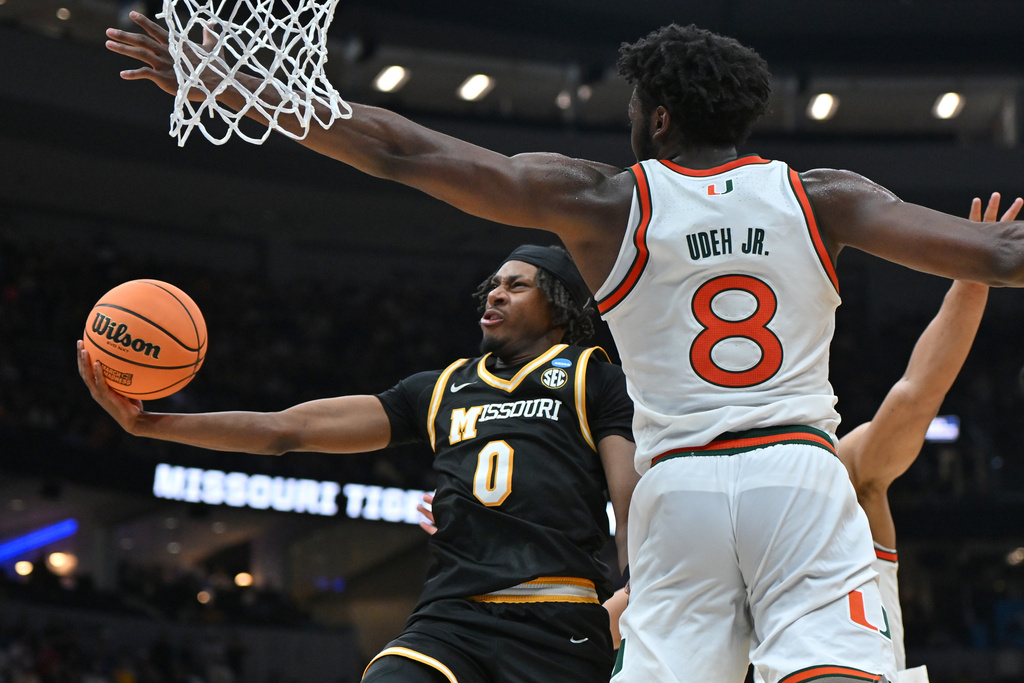 Missouri's Anthony Robinson II (0) heads to the basket as Miami's Ernest Udeh Jr. (8) defends during the first half in the first round of the NCAA college basketball tournament, Friday, March 20, 2026, in St. Louis. (AP Photo/Ali Overstreet)