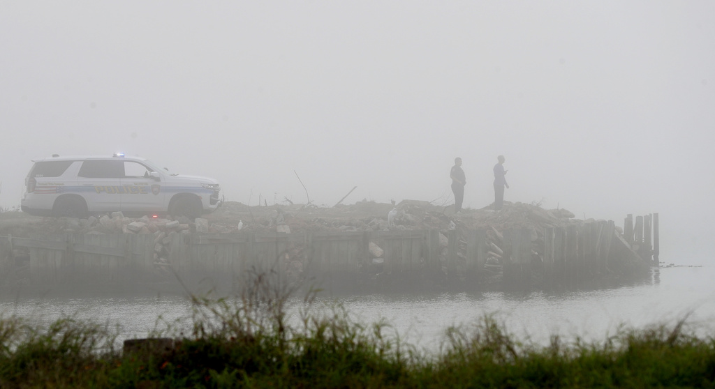 Galveston Police officers watch the water on Galveston Bay west of the Galveston causeway, Monday, Dec. 22, 2025, near Galveston, Texas, as emergency personnel search for a small airplane that went down in the bay in heavy fog. (Jennifer Reynolds/The Galveston County Daily News via AP)