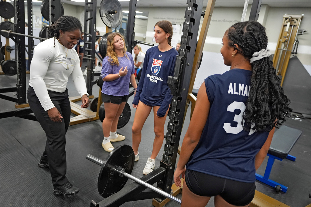 Alonso High School girls flag football coach Letrice Hall, left, works with players in the weight room, Tuesday, Nov. 4, 2025, in Tampa, Fla. (AP Photo/Chris O'Meara)