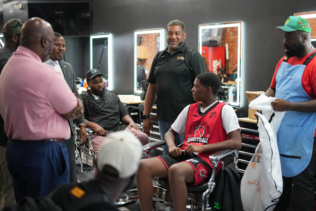 Khalil Thompson, center, co-founder of Win With Black Men, leads a discussion at Philly Cuts barber shop in Philadelphia, Friday, Aug. 21, 2026. (AP Photo/Matt Rourke)
