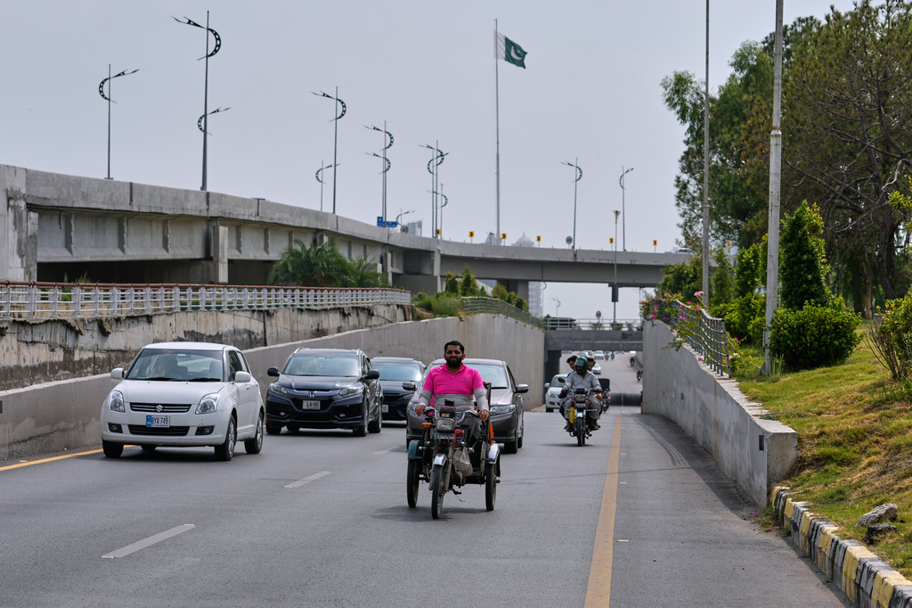 Hamza Ali, 28, who lost both legs in a road accident, rides to deliver a meal order to a customer in Islamabad, Pakistan, Friday, July 17, 2026. (AP Photo/Anjum Naveed)