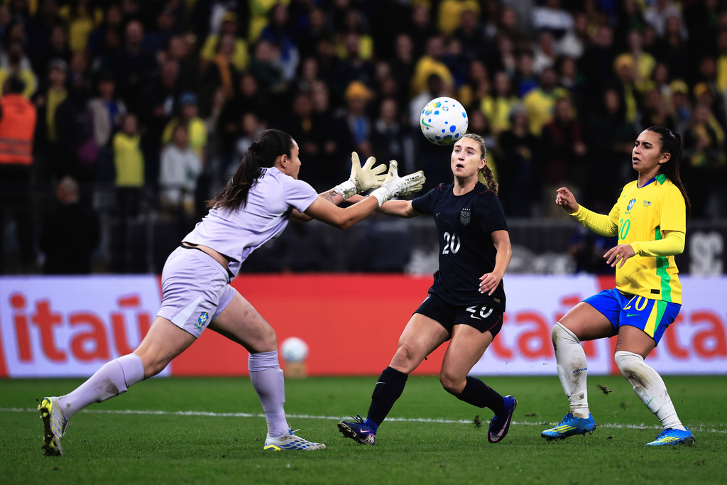 Brazil's goalkeeper Lorena, left, reaches for the ball ahead of United States' Ally Sentnor, center, as Brazil's Mariza looks on during an international friendly women's soccer match in Sao Paulo, Brazil, Saturday, June 6, 2026. (AP Photo/Ettore Chiereguini)