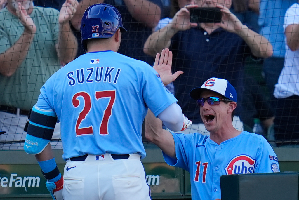 Chicago Cubs' Seiya Suzuki (27), left, high-fives manager Craig Counsell (11) after hitting a grand slam during the seventh inning of a baseball game against the St. Louis Cardinals, Friday, Sept. 26, 2025, in Chicago. (AP Photo/Erin Hooley)