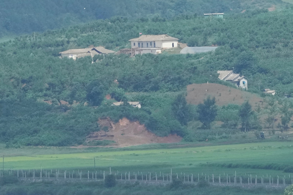 A North Korean flag, center top, flutters in the wind on North Korea's town, Kaepoong, as seen from the unification observatory in Paju, South Korea, Tuesday, July 7, 2026. (AP Photo/Lee Jin-man)