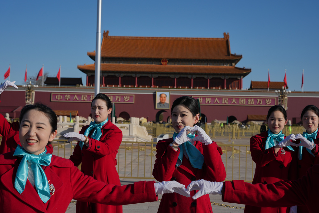 Bus ushers pose for a photo near Tiananmen Gate before a plenary session of the National People's Congress (NPC) held at the Great Hall of the People in Beijing, Monday, March 9, 2026. (AP Photo/Ng Han Guan)