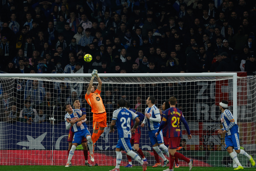 Barcelona's goalkeeper Joan Garcia, top, clears the ball during the Spanish La Liga soccer match between RCD Espanyol and Barcelona in Barcelona, Spain, Saturday, Jan. 3, 2026. (AP Photo/Joan Monfort)