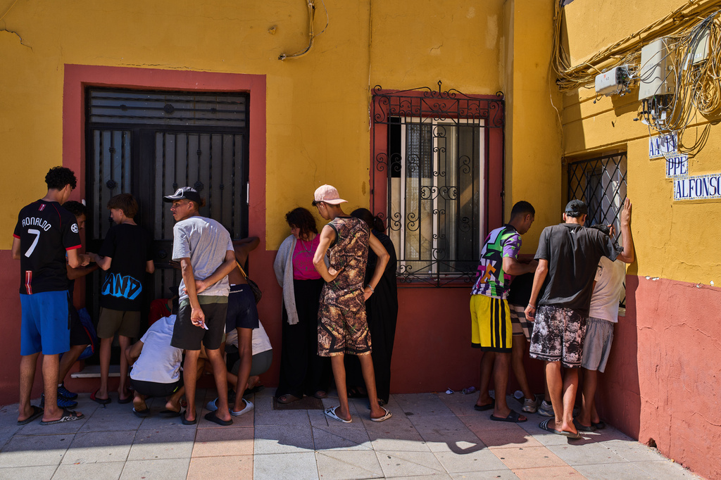 Migrants, some of them unaccompanied minors, who crossed from Morocco into Spain, write down their contact information to give to a neighborhood association in the Spanish enclave of Ceuta, Tuesday, Aug. 4, 2026. (AP Photo/Bernat Armangue)