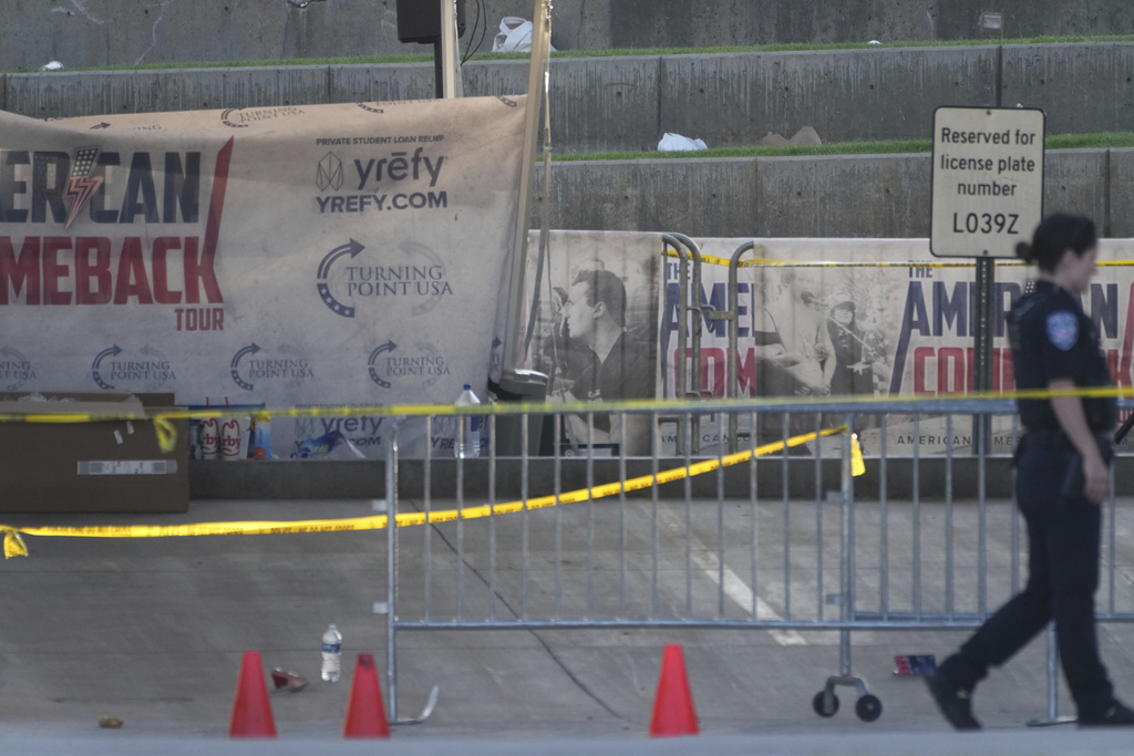 A police officer walks near the scene of the shooting of Charlie Kirk at Utah Valley University in Orem, Utah, Thursday, Sept. 11, 2025. (AP Photo/Lindsey Wasson)