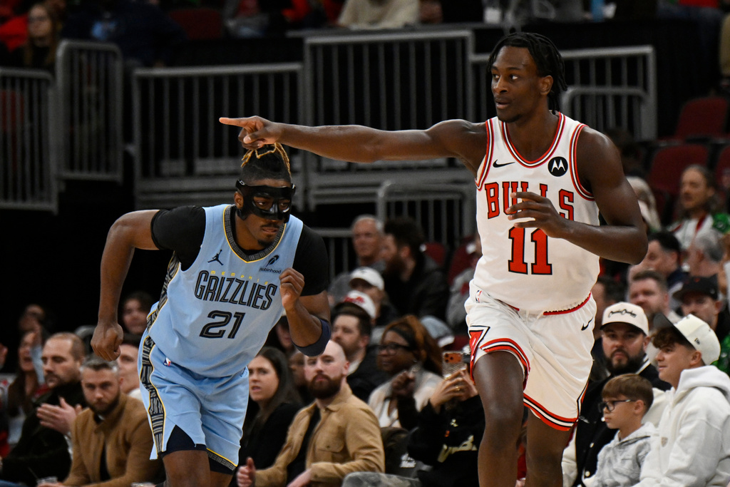 Chicago Bulls' Leonard Miller (11) celebrates after making a 3-point basket while Memphis Grizzlies' Jahmai Mashack (21) looks on during the first half of an NBA basketball game in Chicago, Monday, March 16, 2026. (AP Photo/Paul Beaty)