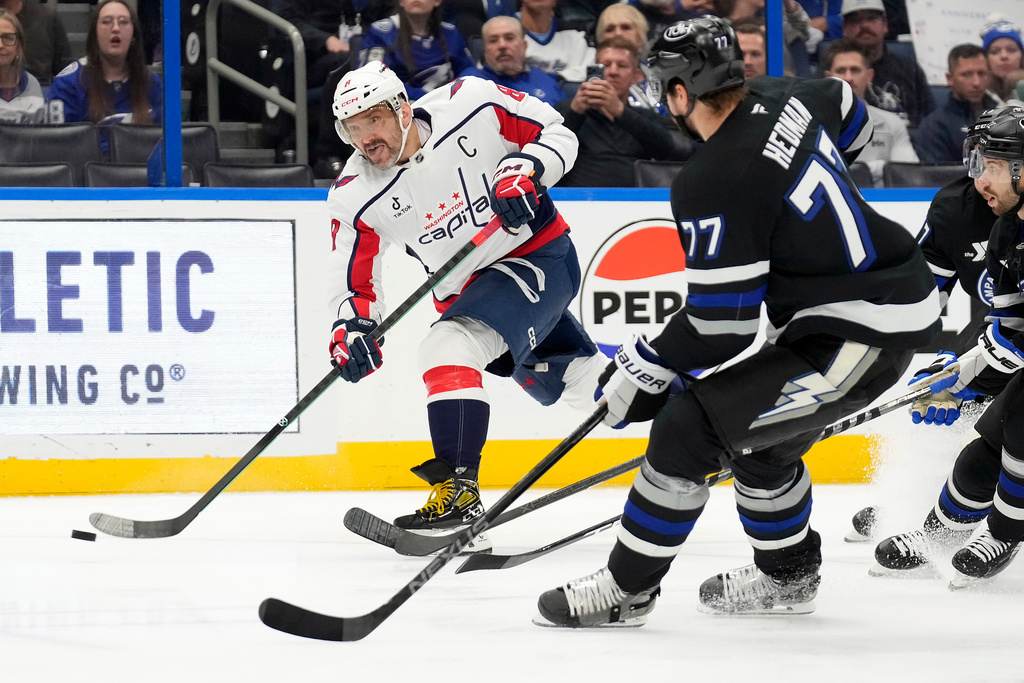 Washington Capitals left wing Alex Ovechkin (8) shoots in front of Tampa Bay Lightning defenseman Victor Hedman (77) during the first period of an NHL hockey game Saturday, Nov. 8, 2025, in Tampa, Fla. (AP Photo/Chris O'Meara)