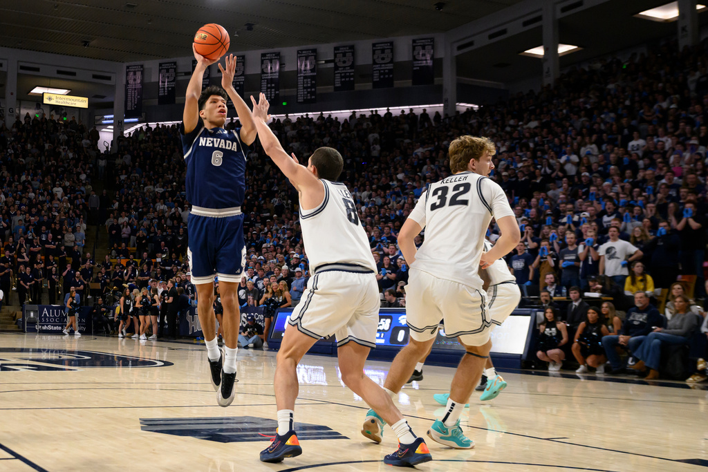 Nevada forward Kaleb Lowery, left, shoots over Utah State guard Drake Allen, center, during the first half of an NCAA college basketball game, Wednesday, Jan. 14, 2026, in Logan, Utah. (AP Photo/Tyler Tate)