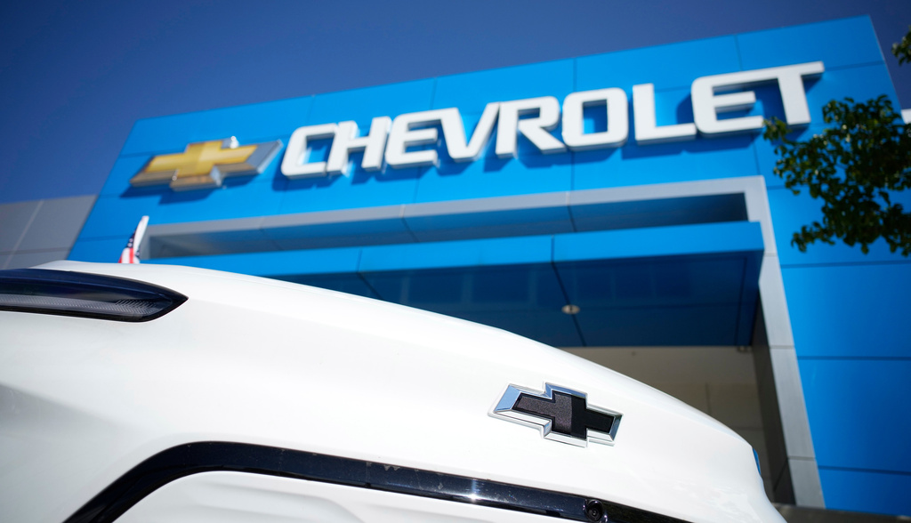 FILE - The company logo shines off the nose of an unsold 2022 Bolt electric vehicle on display in front of a Chevrolet dealership Sunday, Sept. 12, 2021, in Englewood, Colo. (AP Photo/David Zalubowski, File)