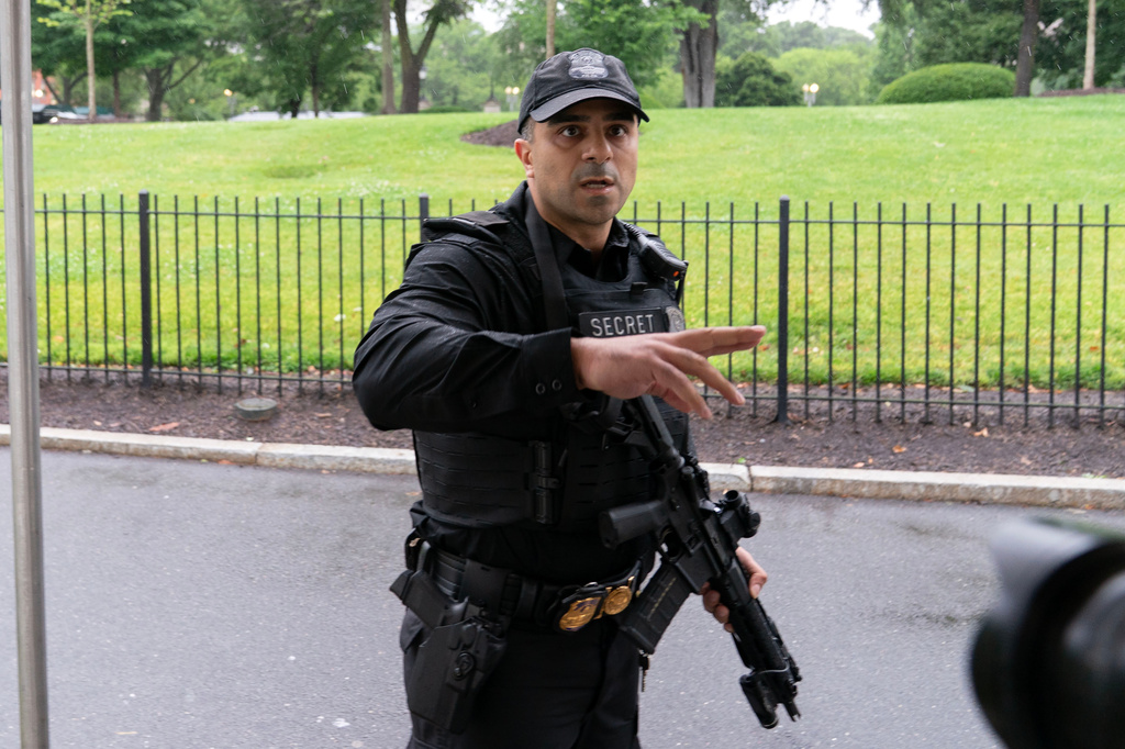 A member of the Secret Service stops journalists from leaving the White House, Saturday, May 23, 2026, in Washington. (AP Photo/Jose Luis Magana)