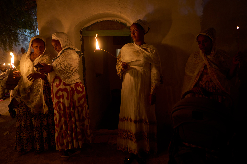 Ethiopian Orthodox Christian worshippers hold candles on the eve of the Meskel holiday at the Ethiopian monks' village, Deir Al‑Sultan, located on the rooftop of the Church of the Holy Sepulcher in Jerusalem's Old City, Saturday, Sept. 26, 2026. (AP Photo/Ohad Zwigenberg)