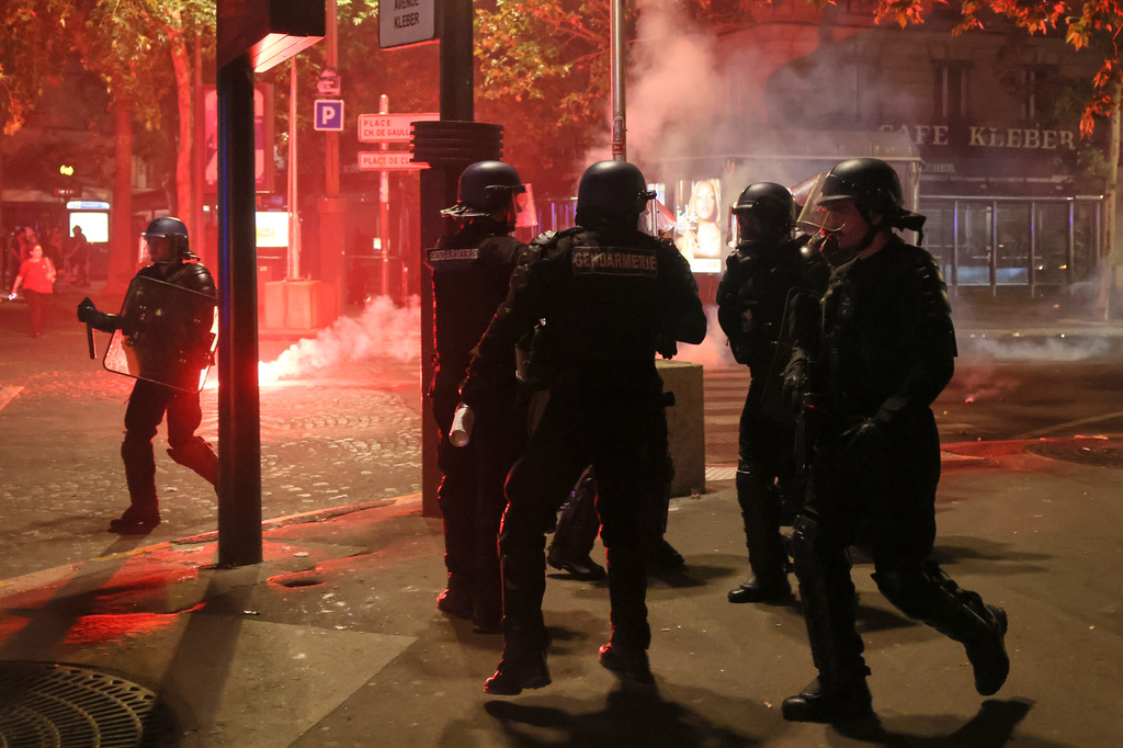 Police try to disperses PSG supporters who left off fireworks as they celebrate in Paris, Saturday, May 30, 2026 after the Champions League final soccer match between Paris Saint-Germain and Arsenal that was played in Budapest, PSG won the game. (AP Photo/Thomas Padilla)