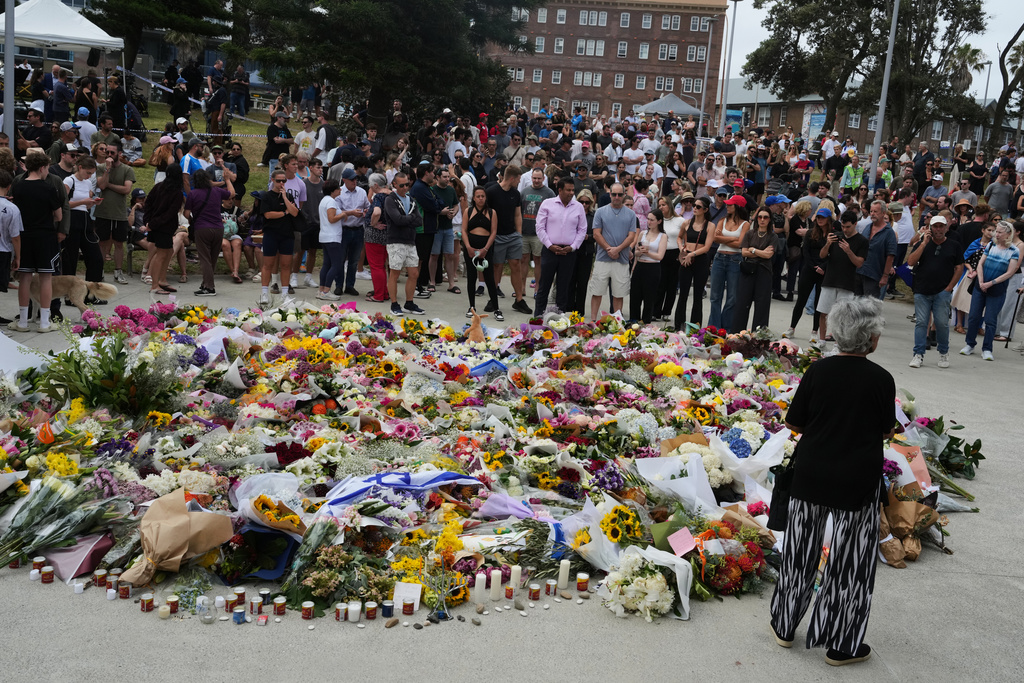 People gather at a growing flower memorial to shooting victims outside the Bondi Pavilion at Sydney's Bondi Beach, Monday, Dec. 15, 2025, a day after a shooting. (AP Photo/Mark Baker)
