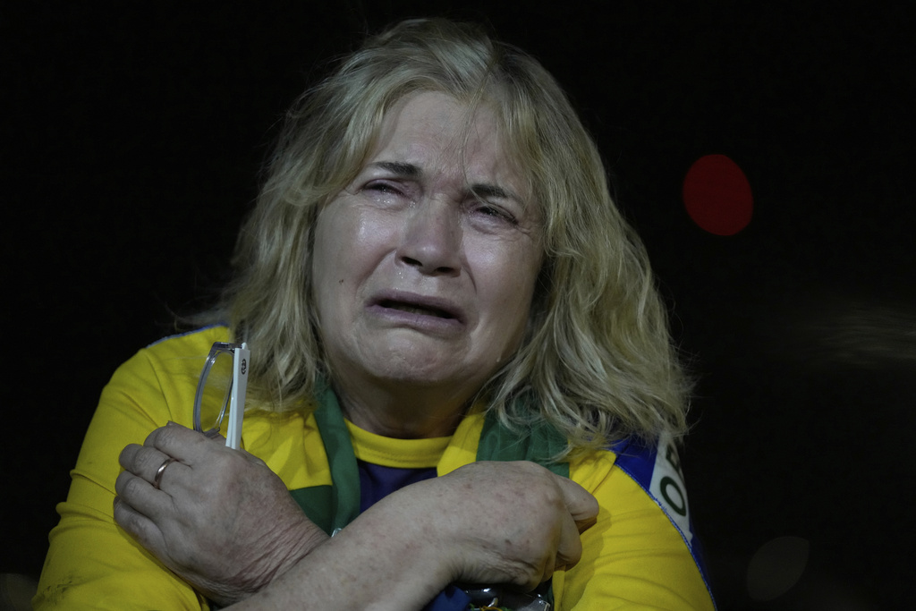 A supporter of former President Jair Bolsonaro cries during a vigil in his support near his home where he is under house arrest in Brasilia, Brazil, Thursday, Sept. 11, 2025. (AP Photo/Eraldo Peres)