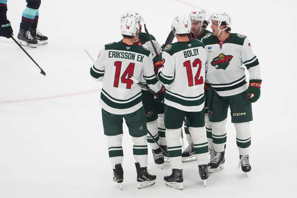 Minnesota Wild defenseman Brock Faber, far right, celebrates his goal against the Seattle Kraken with center Joel Eriksson Ek (14) and left wing Matt Boldy (12) during the first period of an NHL hockey game Thursday, Jan. 8, 2026, in Seattle. (AP Photo/Lindsey Wasson)