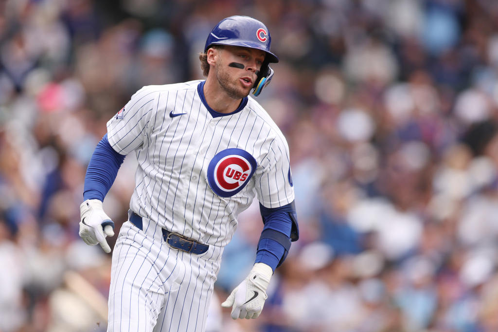Chicago Cubs Nico Hoerner (2) runs to first after hitting a single during the fourth inning of a baseball game against the Washington Nationals on Sunday, March 29, 2026, in Chicago. (AP Photo/Geoff Stellfox)