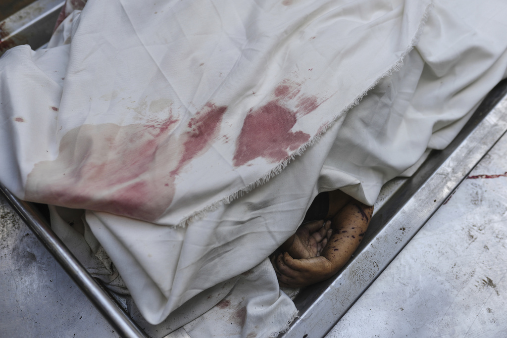 The bodies of members of the Al-Basus family, killed in an Israeli military strike, are covered during their funeral outside Shifa Hospital in Gaza City on Thursday, Sept. 4, 2025. (AP Photo/Jehad Alshrafi)