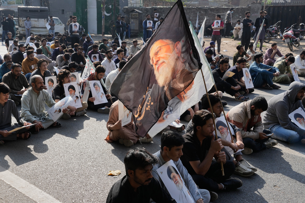 Pakistani Shiite Muslims sit on a road during a demonstration to condemn the death of Iranian Supreme Leader Ayatollah Ali Khamenei in a major attack by Israel and the United States, in Lahore, Pakistan, Sunday, March 1, 2026. (AP Photo/K.M. Chaudary)