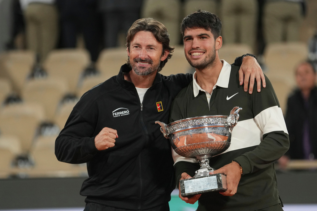 FILE - Spain's Carlos Alcaraz, right, poses with his coach Juan Carlos Ferrero after winning the final match of the French Tennis Open against Italy's Jannik Sinner at the Roland-Garros stadium in Paris, Sunday, June 8, 2025. (AP Photo/Thibault Camus, File)