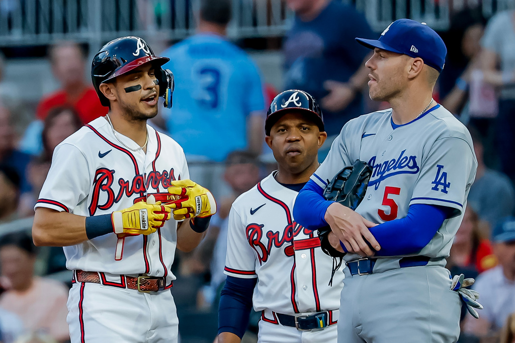 Atlanta Braves' Mauricio Dubón, left, reacts with Los Angeles Dodgers first baseman Freddie Freeman (5), after Dubón hit an RBI single during the first inning of a baseball game, Tuesday, August 25, 2026, in Atlanta. (AP Photo/Erik S. Lesser)