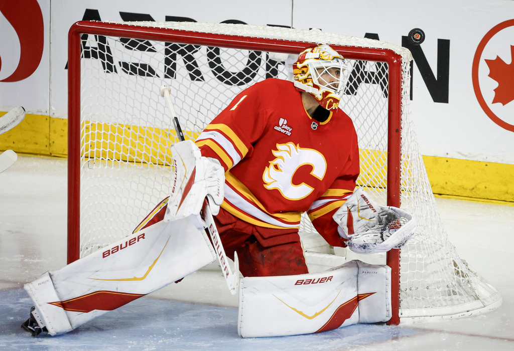 Calgary Flames goalie Devin Cooley stares down the puck during the third period of an NHL hockey game against the Vegas Golden Knights in Calgary, Alberta, Saturday, Dec. 20, 2025. (Jeff McIntosh/The Canadian Press via AP)