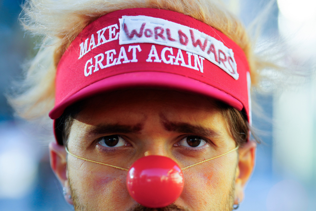 A man dressed as a clown waits for the start of a demonstration against President Trump and the Annual Meeting of the World Economy Forum in Davos, Switzerland, Sunday, Jan. 18, 2026. (AP Photo/Markus Schreiber)