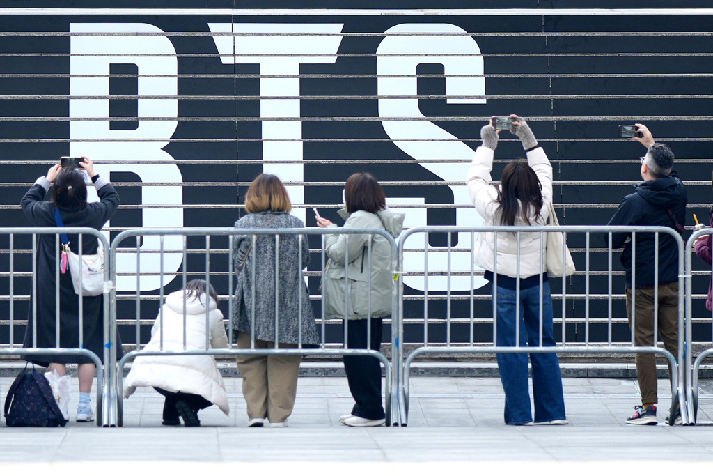 Fan of K-pop band BTS in front of a logo of BTS in Seoul, South Korea, Monday, March 16, 2026. (AP Photo/Lee Jin-man)