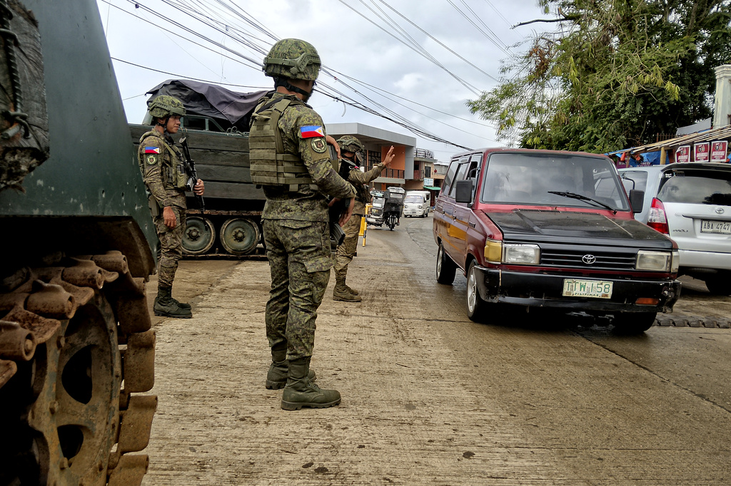 In this photo taken with a smartphone, Army soldiers check the flow of vehicular traffic along the highway in Marantao town, Lanao del Sur province, southern Philippines on Sunday Sept 13, 2026. (AP Photo/ Froilan Gallardo)