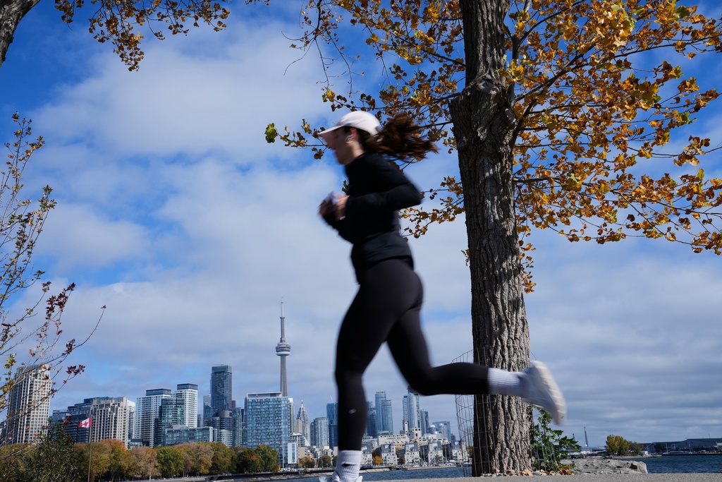 A woman runs at the Trillium Park by Lake Ontario, Toronto, Wednesday, Oct. 29, 2025. (AP Photo/Kamran Jebreili)
