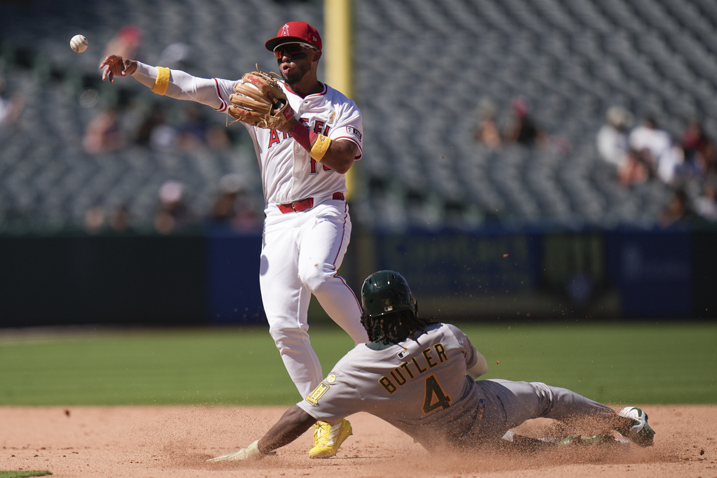Los Angeles Angels shortstop Oswald Peraza (10) throws to first base to complete a double play after forcing out Athletics' Lawrence Butler (4) during the seventh inning of a baseball game Sunday, Sept. 7, 2025, in Anaheim, Calif. (AP Photo/Jae C. Hong)