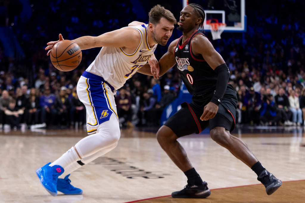 Los Angeles Lakers' Luka Doncic, left, makes his move against Philadelphia 76ers' Tyrese Maxey during the first half of an NBA basketball game, Sunday, Dec. 7, 2025, in Philadelphia. (AP Photo/Chris Szagola)