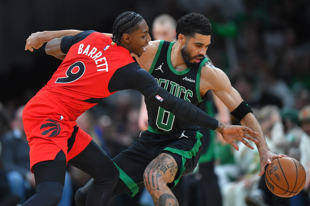 Boston Celtics forward Jayson Tatum, right, tries to drive past Toronto Raptors forward RJ Barrett in the first half of an NBA basketball game, Sunday, April 5, 2026, in Boston. (AP Photo/Steven Senne)