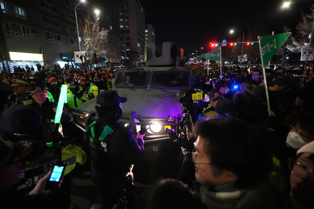 FILE - Military vehicle is escorted by police officers as people try to block outside of the National Assembly in Seoul, South Korea, Dec. 4, 2024. (AP Photo/Lee Jin-man, File)
