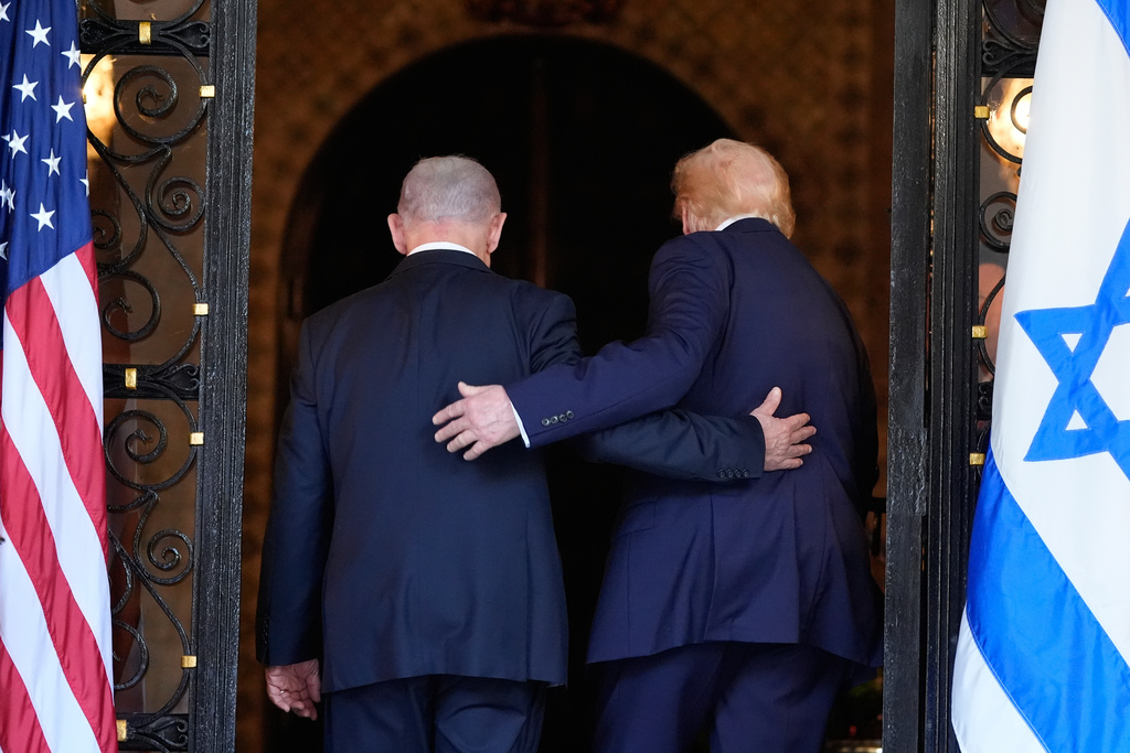 FILE - President Donald Trump and Israel's Prime Minister Benjamin Netanyahu walk arm in arm into Trump's Mar-a-Lago club in Palm Beach, Fla., Dec. 29, 2025. (AP Photo/Alex Brandon, File)