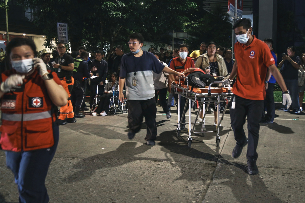 Medical workers bring a resident outside after a strong earthquake struck Cebu city, central Philippines, on Tuesday Sept. 30, 2025. (AP Photo/Jacqueline Hernandez)