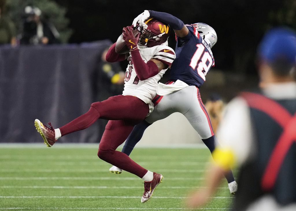 Washington Commanders cornerback Bobby Price (37) and New England Patriots wide receiver Kyle Williams (18) reach for a pass during the first half of an NFL preseason football game Friday, Aug. 8, 2025, in Foxborough, Mass. (AP Photo/Charles Krupa)