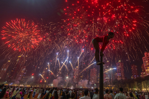 A girl performs on a mallakhamb pole as fireworks light up the sky during the Diwali festival of lights in Mumbai, India, on Monday, Oct. 20, 2025. (AP Photo/Rafiq Maqbool) A girl performs on a mallakhamb pole as fireworks light up the sky during the Diwali festival of lights in Mumbai, India, on Monday, Oct. 20, 2025. (AP Photo/Rafiq Maqbool)