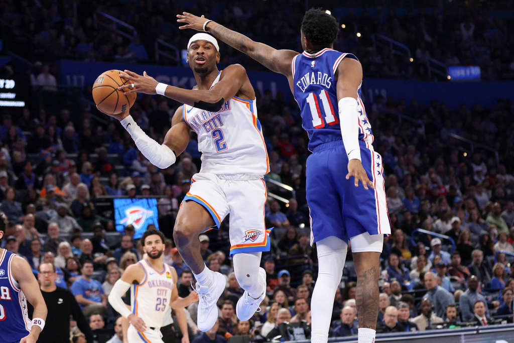 Oklahoma City Thunder guard Shai Gilgeous-Alexander (2) looks to pass the ball away from Philadelphia 76ers forward Justin Edwards (11) during the second half of an NBA basketball game Sunday, Dec. 28, 2025, in Oklahoma City. (AP Photo/Nate Billings)