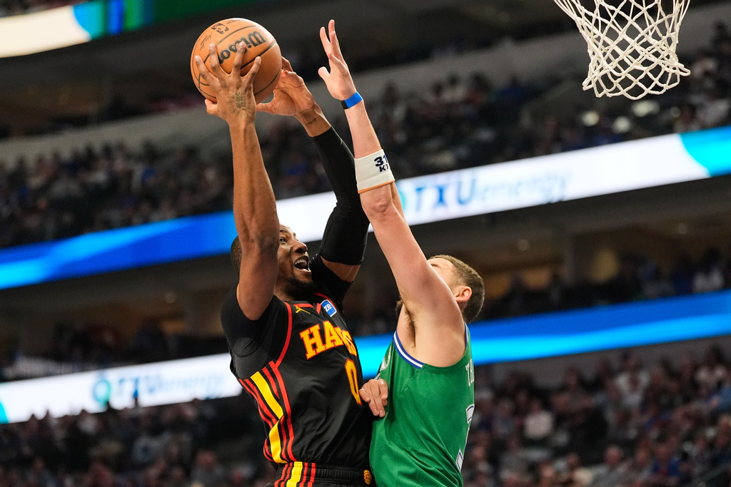 Atlanta Hawks forward Jonathan Kuminga (0) shoots over Dallas Mavericks' Klay Thompson (31) in the first half of a NBA basketball game in Dallas, Wednesday, March 18, 2026. (AP Photo/Tony Gutierrez)