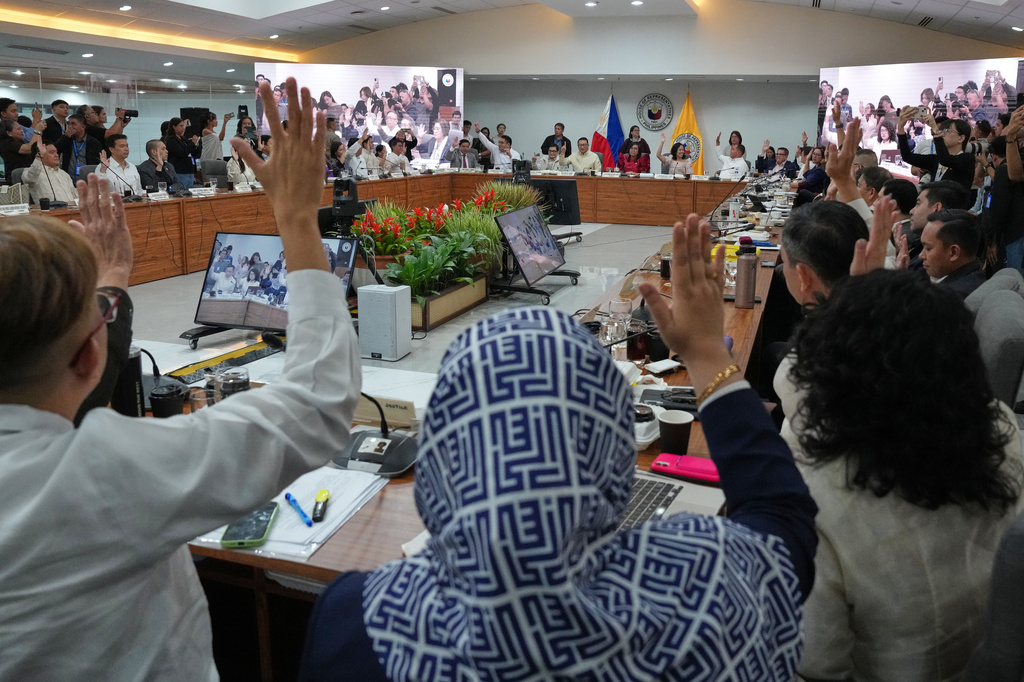 Members of Congress justice committee raise their hands as they vote during a congressional hearing on an impeachment bid against Vice President Sara Duterte at the House of Representatives in Quezon, Philippines Wednesday, April 29, 2026. (AP Photo/Aaron Favila)