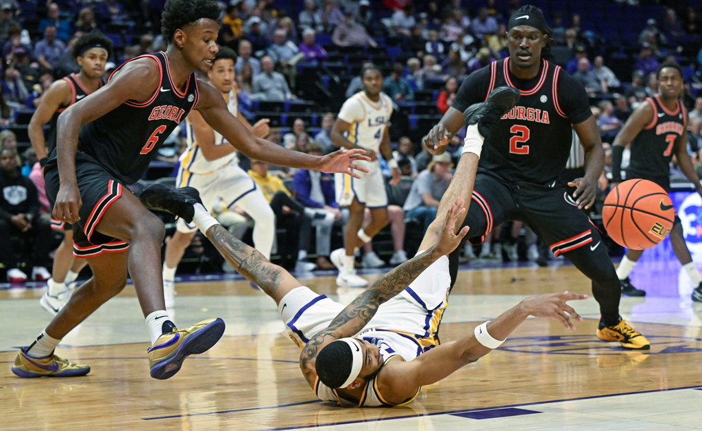 LSU forward Robert Miller III (6) throws the ball to a teammate after falling onto the court as Georgia forward Kanon Catchings (6) and center Somtochukwu Cyril (2) look on during an NCAA college basketball game, Saturday, Feb. 7, 2026, in Baton Rouge, La. (Hilary Scheinuk/The Advocate via AP)